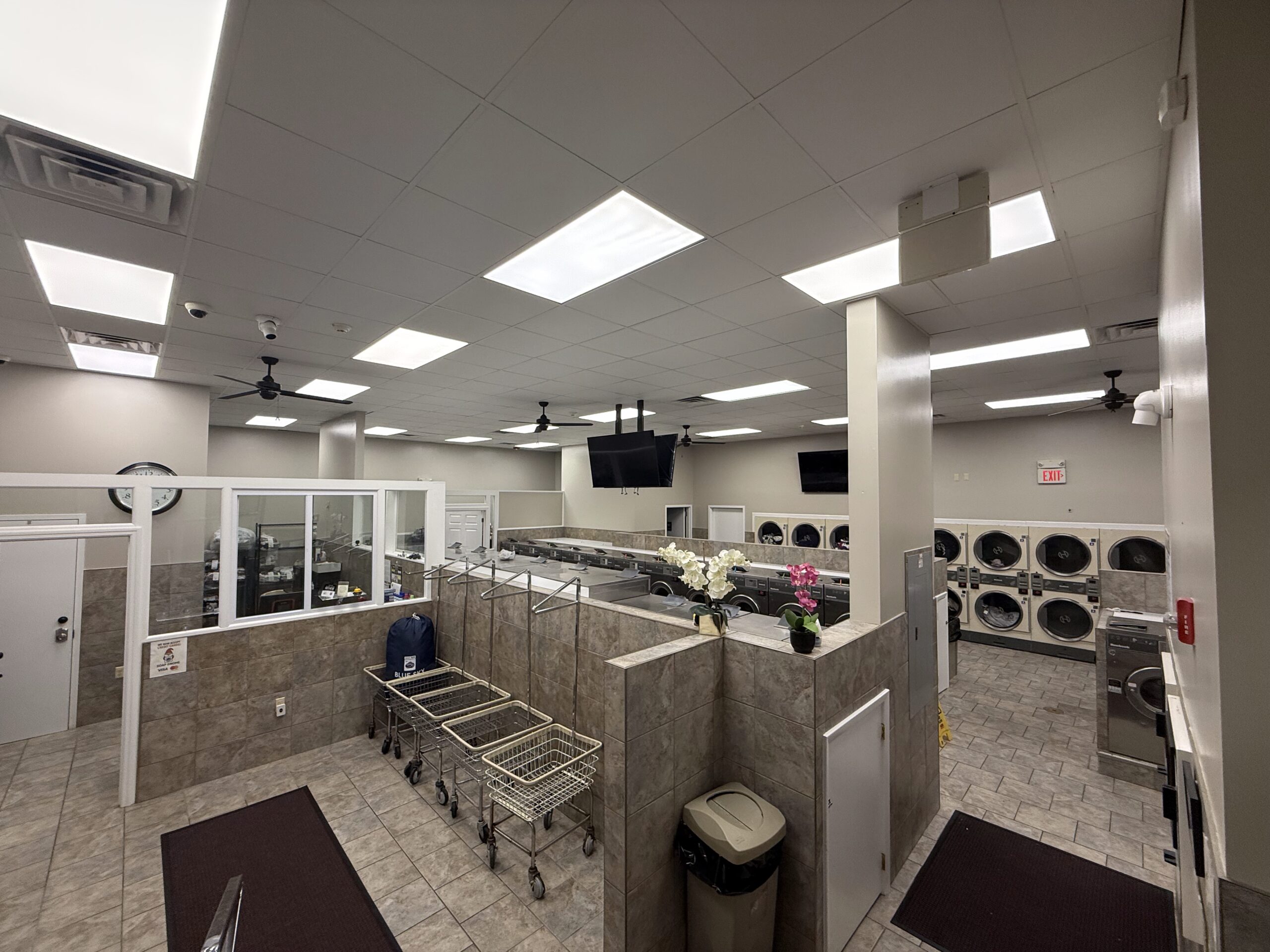 Row of large front-load washing machines inside the laundromat